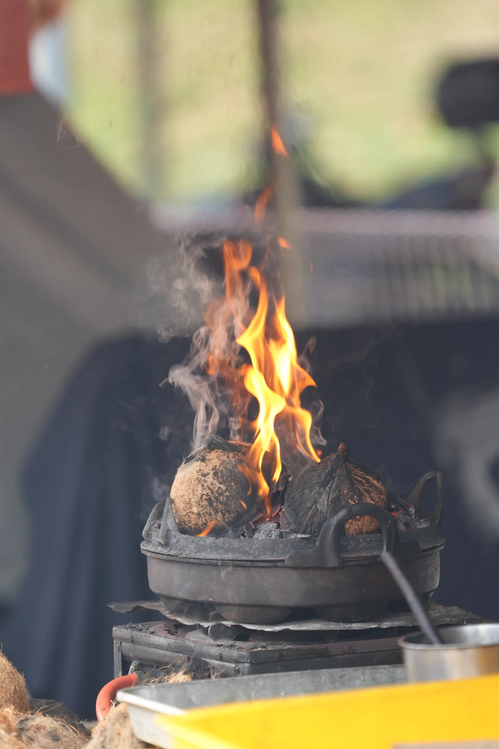 Charcoal fire and coconut husks ablaze — preparing the grill at the bazaar