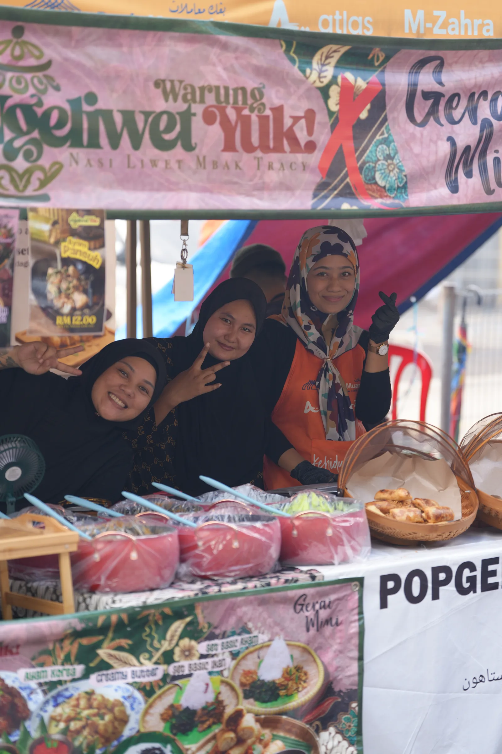 Young vendors posing at their stall — smiles and community at the Ramadhan bazaar