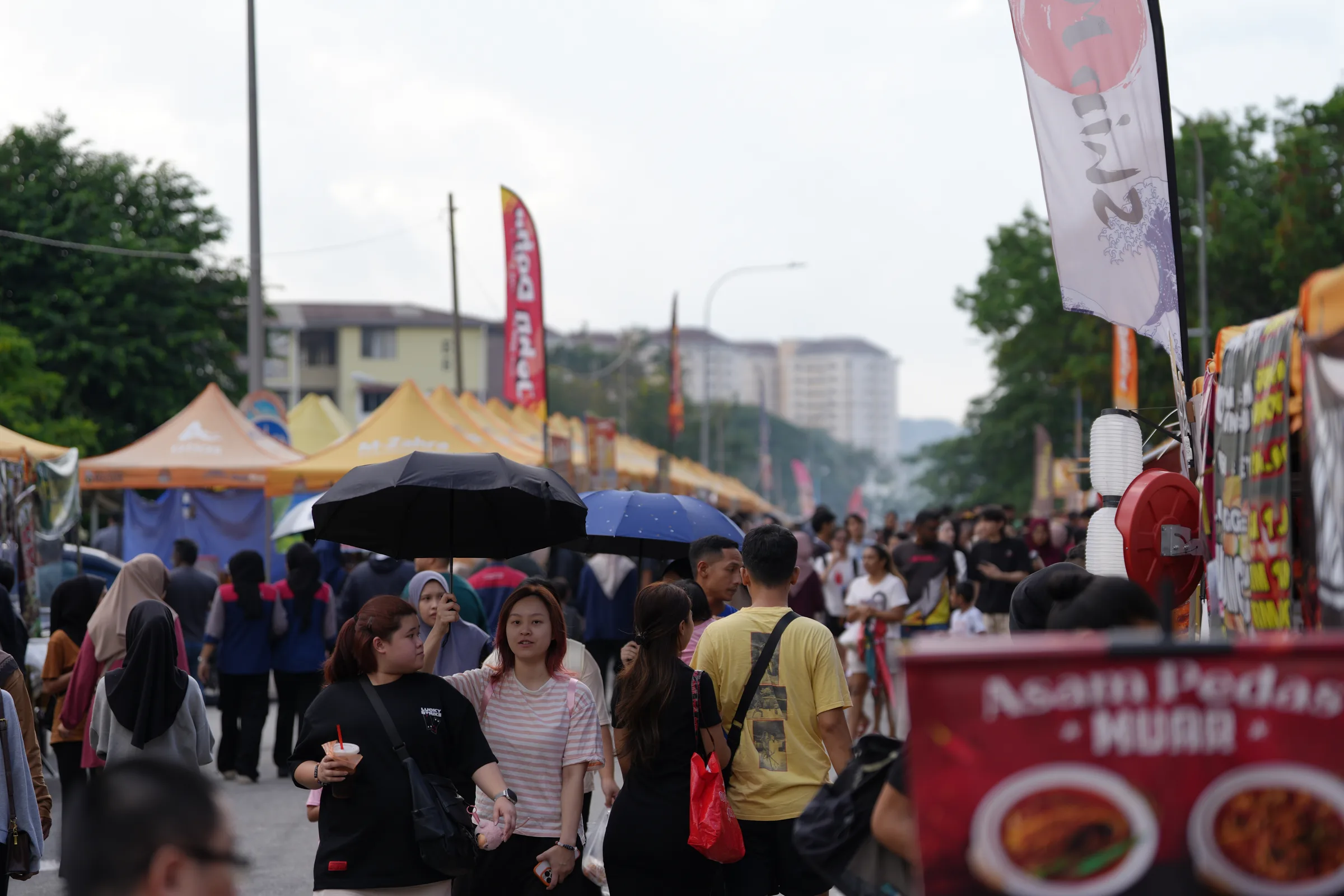 Crowded bazaar walkway with yellow tents stretching into the distance — Wangsa Maju