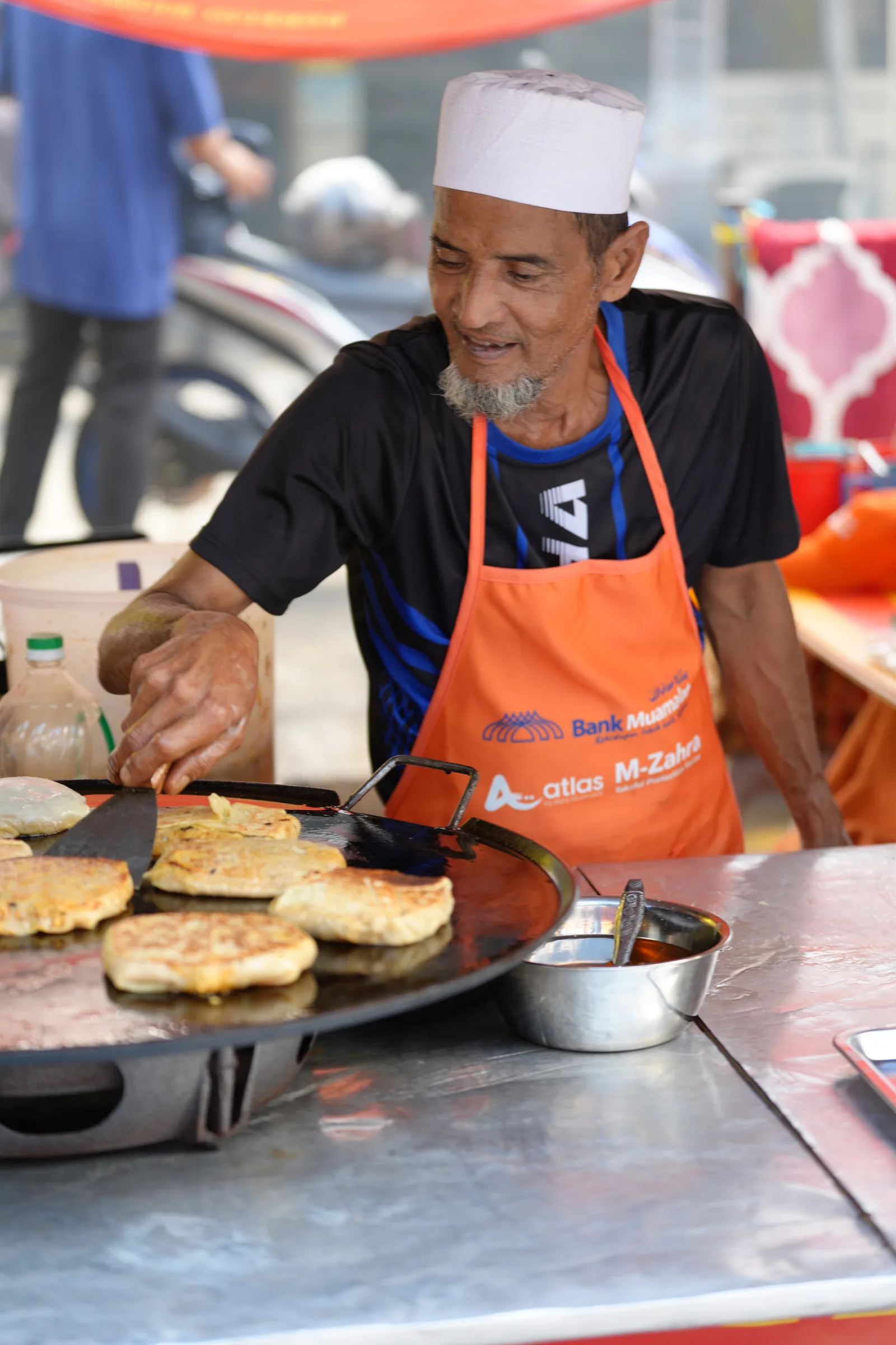 Murtabak vendor flipping on the griddle — Ramadhan bazaar food photography
