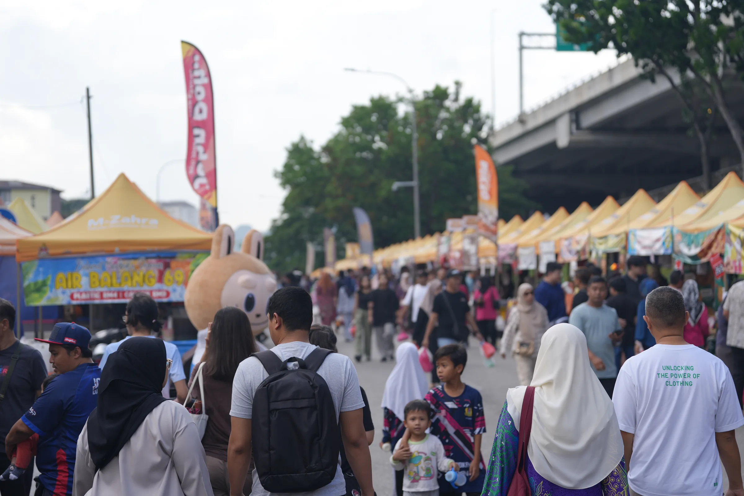 Bazaar crowds beneath the highway overpass — families gathering for iftar shopping