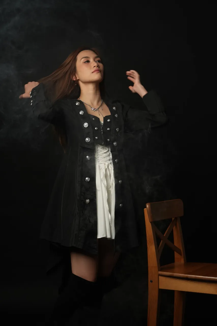 Arms raised through the hair, smoke catching the key light