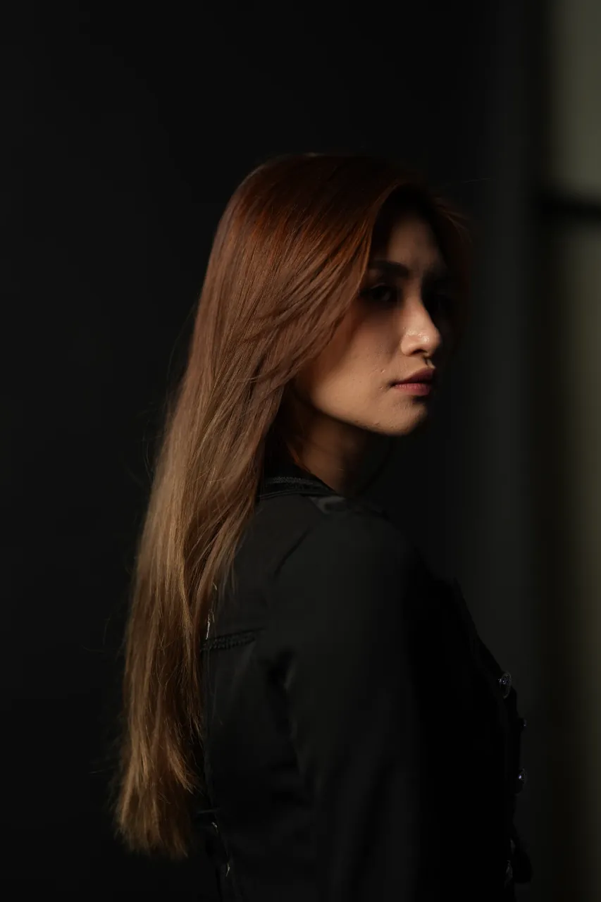 Side profile against a darkened studio wall