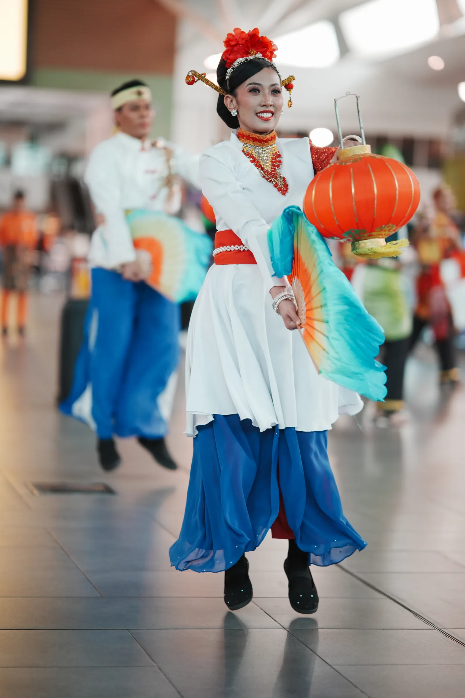 Chinese-heritage dancer with lantern and rainbow fan — multicultural Malaysia