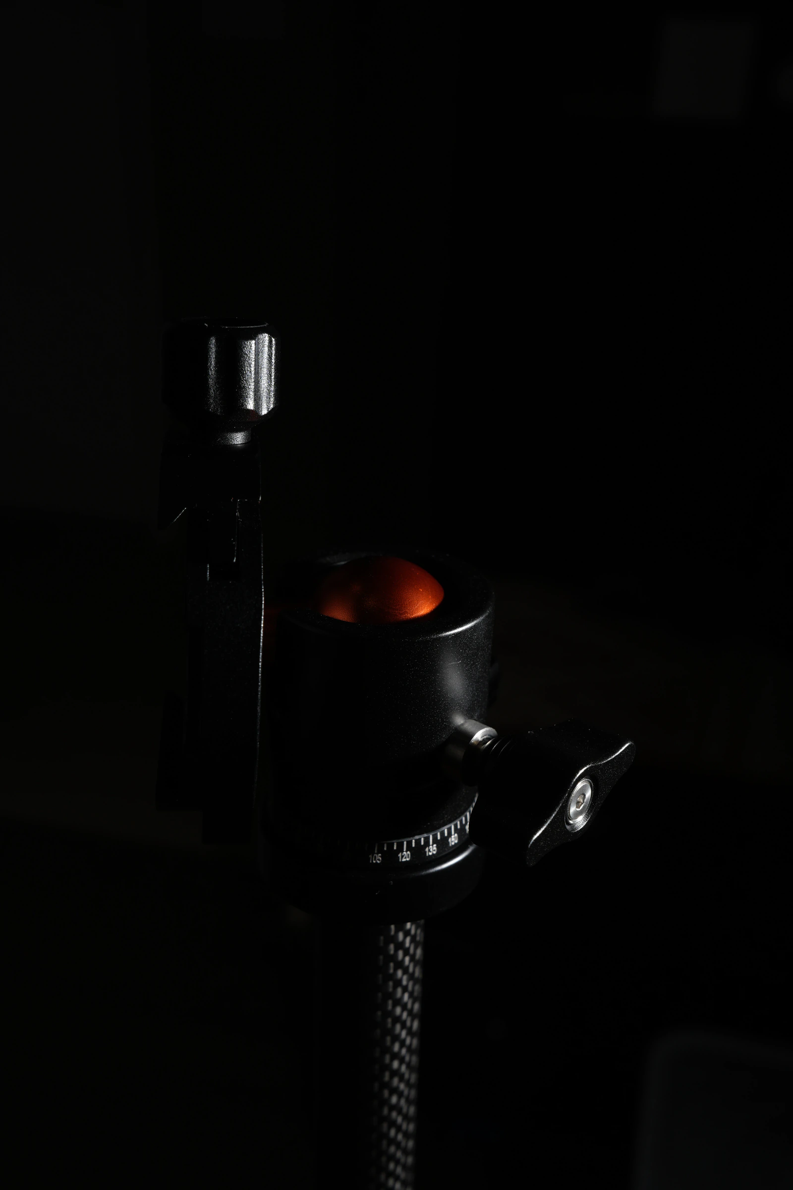 Product photography — tripod ball head detail in dark-field lighting